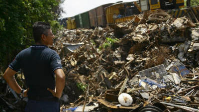 Un oficial de la Policía observa mientras miembros del Ejercito Mexicano remueven los escombros del tren conocido como La Bestia.