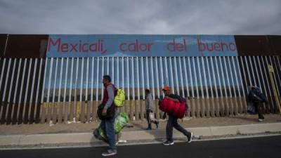 La grueso de la caravana caminaba hacia la salida de la ciudad, para de ahí pedir 'aventón' AFP