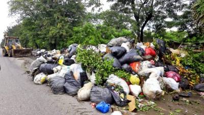 Una retroexcavadora recoge basura acumulada en la CA-5. Las unidades permanecerán en la zona hasta limpiar por completo, luego irán a Pimienta y Potrerillos, adonde las aguas aún no bajan. Fotos: Moisés Valenzuela.