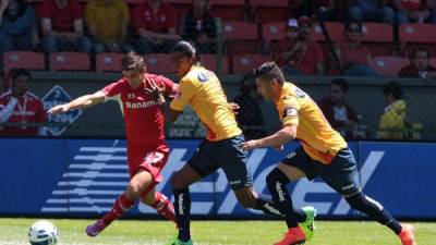 El jugador Isaac Brizuela (i), de Toluca, disputa un balón con Joel Huiqui (c) y Carlos Morales (d), de Morelia.