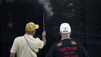 Familiares de los soldados caídos en la guerra de Vietnam buscan nombres en el memorial de Washington.