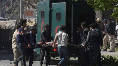 TOPSHOT - A car bomb attack victim on a stretcher is carried to an ambulance at the site of the blast in Kabul on May 31, 2017.A massive blast rocked Kabul's diplomatic quarter during the morning rush hour on May 31, the latest attack to hit the Afghan capital. / AFP PHOTO / SHAH MARAI