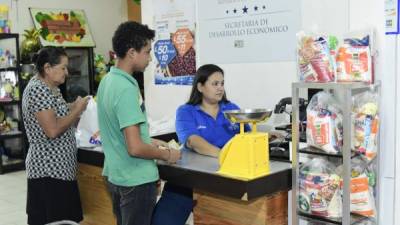 Servicio. Dos consumidores mientras pagan sus compras en el Megasupro del barrio Paz Barahona. Foto: Yoseph Amaya.