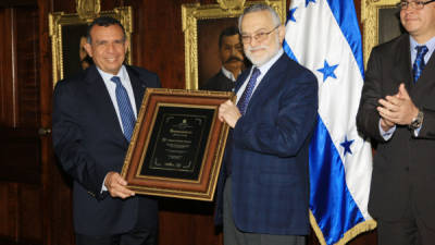 El presidente de Honduras le entrega un reconocimiento al científico hondureño, Salvador Moncada.