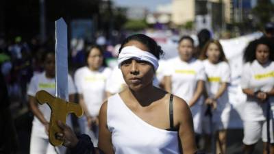 Artistas realizan una presentación en homenaje a mujeres privadas de libertad, este viernes durante la marcha para conmemorar el Día Internacional de la Mujer, en San Salvador (El Salvador). EFE