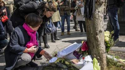 Varias personas depositaban ayer flores en el lugar en el que fue asesinado la noche del jueves un policía durante un ataque yihadista perpetrado en la avenida de los Campos Elíseos de París, Francia. EFE