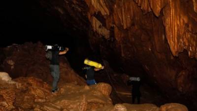 Voluntarios tailandeses transportan oxígeno para los buzos británicos que buscan a un equipo infantil de fútbol desaparecido en una cueva inundada de Tailandia./AFP.