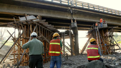 Columnas de madera sostienen la parte que estuvo hundida. La nivelación del puente está a punto de finalizar.