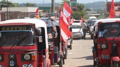 Mototaxis decorados con banderas liberales en un centro electoral de Villanueva.