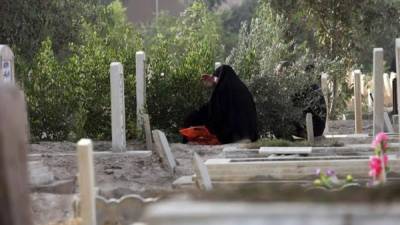 Una mujer reza frente a la tumba de un familiar en un cementerio de Faluya, Irak. EFE/Archivo
