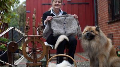 María Barz muestra un jersey tejido con la lana de su perro.