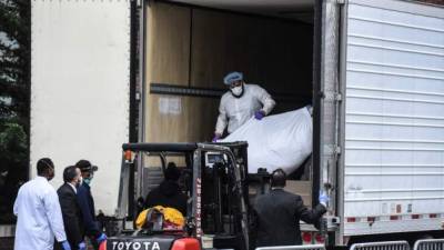 Las autoridades sanitarias colocan los cuerpos de las víctimas del coronavirus en camiones refrigerados estacionados a las afueras de los hospitales en Nueva York./AFP.