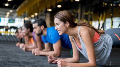 Group of people exercising at the gym in a suspension training class â?? fitness concepts