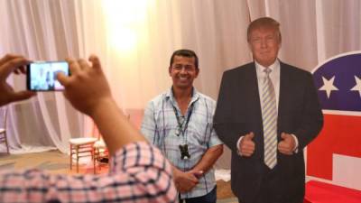 Un periodista capitalino posa junto a la figura de Donald Trump.
