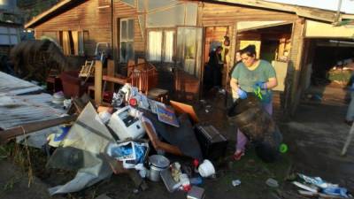 Una residente saca sus pertenencias para secarlas afuera de su casa en Concón, a unos 110 km al noroeste de Santiago.