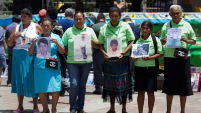 Un grupo de mujeres sostienen retratos de sus familiares desaparecidos el martes 30 de agosto de 2016 en Tegucigalpa. EFE