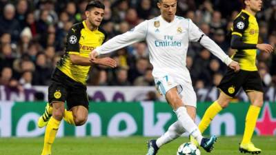 GRAF5310. MADRID, 06/12/2017.- El delantero portugués del Real Madrid Cristiano Ronaldo (c) pelea un balón con el centrocampista del Borussia Dortmund Mahmoud Dahoud (i), durante el partido de la sexta jornada de la fase de grupos de la Liga de Campeones que se juega esta noche en el estadio Santiago Bernabéu, en Madrid. EFE/Rodrigo Jiménez