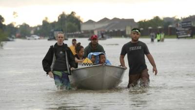 HOUSTON, TX - AUGUST 29: The Tellez family is evacuated from their home after severe flooding following Hurricane Harvey in north Houston August 29, 2017 in Houston, Texas. Harvey, which made landfall north of Corpus Christi late Friday evening, is expected to dump upwards of 40 inches of rain over the next couple of days. Win McNamee/Getty Images/AFP== FOR NEWSPAPERS, INTERNET, TELCOS & TELEVISION USE ONLY ==