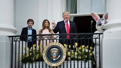 Barron Trump (L) and US First Lady Melania Trump (2L) listen as US President Donald Trump (2R) speaks during the Easter Egg Roll on the South Lawn of the White House April 17, 2017 in Washington, DC. / AFP PHOTO / Brendan Smialowski