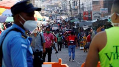 Cientos de personas aprovechan la apertura de los comercios, este lunes en los mercados de Tegucigalpa. Fotos: EFE