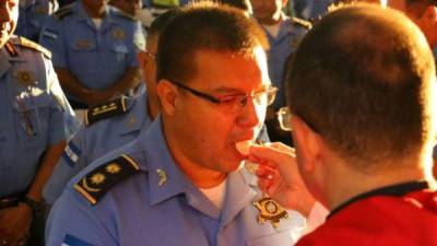 Un oficial de la Policía Nacional comulga ante un sacerdote durante una misa oficiada en Tegucigalpa.