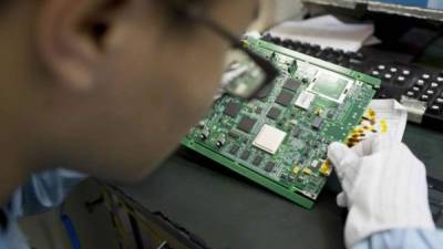 Un empleado inspecciona un circuito en las instalaciones de la empresa ZTE