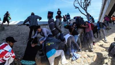 Un grupo de migrantes fue registrado este domingo al tratar de cruzar la garita El Chaparral, en la frontera méxico-estadounidense, en la ciudad de Tijuana (estado de Baja California, México). EFE