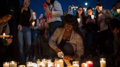 LAS VEGAS, NV - OCTOBER 2: Mourners light candles during a vigil at the corner of Sahara Avenue and Las Vegas Boulevard for the victims of Sunday night's mass shooting, October 2, 2017 in Las Vegas, Nevada. Late Sunday night, a lone gunman killed more than 50 people and injured more than 500 people after he opened fire on a large crowd at the Route 91 Harvest Festival, a three-day country music festival. The massacre is one of the deadliest mass shooting events in U.S. history. Drew Angerer/Getty Images/AFP== FOR NEWSPAPERS, INTERNET, TELCOS & TELEVISION USE ONLY ==