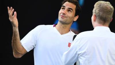 El suizo Roger Federer habla con el ex tenista estadounidense Jim Courier después de su victoria contra Tennys Sandgren de los EE. UU. En su partido de cuartos de final individual masculino en el día nueve del torneo de tenis del Abierto de Australia en Melbourne el 28 de enero de 2020. / AFP