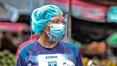 Una mujer con mascarilla y escudo facial como protección contra el coronavirus camina en Tegucigalpa (Honduras). EFE