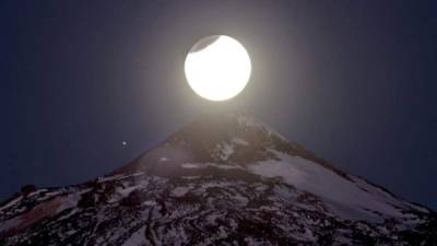 Fotografía facilitada por el IAC del eclipse lunar en el Teide (Tenerife), tomada poco antes del amanecer desde las cercanías del observatorio de Izaña, donde Canarias ha sido el único punto de Europa desde el que se ha podido contemplar esta madrugada la primera fase del eclipse total de la Luna, que duró 40 minutos. EFE/Daniel López