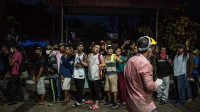 Migrantes hondureños esperan recibir alimentos de un grupo de voluntarios del albergue de migrantes de Esquipulas. EFE