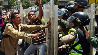 Opositores han tenido que enfrentar a las fuerzas de seguridad que les impiden marchar. AFP