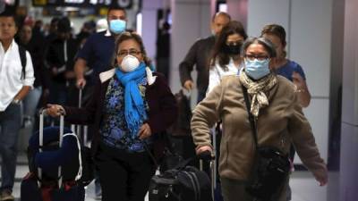 Viajeros arriban este jueves al aeropuerto internacional de San Salvador.