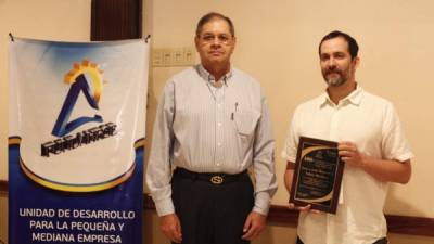 Roberto Leiva, director ejecutivo de Fundahrse, entrega un reconocimiento a un empresario. Foto: Melvin Cubas