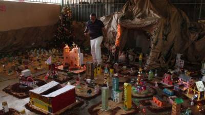 Los reos elaboraron un gran nacimiento rodeado de figuras representativas de San Pedro Sula. Monseñor bendice a los presos. fotos: jorge monzón