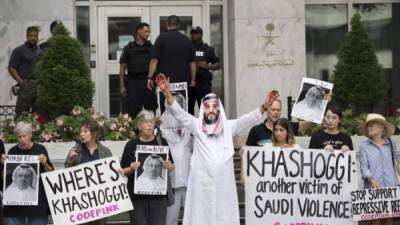 A demonstrator dressed as Saudi Arabian Crown Prince Mohammed bin Salman (C) with blood on his hands protests with others outside the Saudi Embassy in Washington, DC, on October 8, 2018, demanding justice for missing Saudi journalist Jamal Khashoggi. - US President Donald Trump said October 10, 2018 he has talked to Saudi authorities 'at the highest level' to demand answers over what happened to missing journalist Jamal Khashoggi.Trump told reporters at the White House that he talked to the Saudi leadership 'more than once' since Khashoggi, a US resident and Washington Post contributor, vanished on October 2 after entering the Saudi consulate in Istanbul. (Photo by Jim WATSON / AFP)