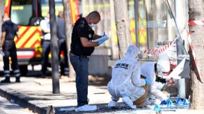 Investigadores recogen evidencia en una de las paradas de autobús envestidas por una persona a la que hasta ahora se considera un desequilibrado mental y no un terrorista.