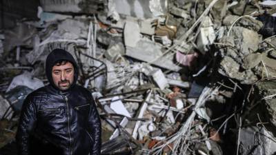 Un hombre espera mientras el personal de emergencia busca víctimas en el sitio de un edificio derrumbado después de un terremoto, hoy, en el distrito de Iskenderun de Hatay, Turquía.