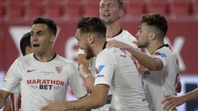 Jugadores del Sevilla felicitando a su compañero Lucas Ocampos tras el gol del volante por la vía penal. Foto AFP.