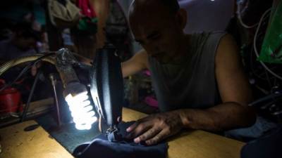 Empleado de una zapatería en el centro de San Pedro Sula trabaja con material para elaborar calzado.