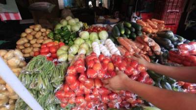 Un locatario acomoda tomates en un puesto del mercado Dandy (Foto: Moisés Valenzuela).
