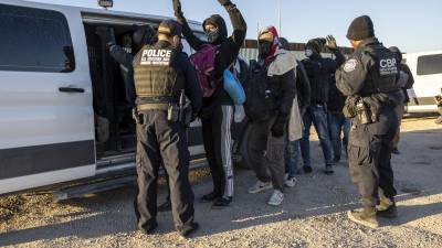 Migrantes son revisados por agentes de la Patrulla Fronteriza antes de ser transportados a centros de detención.