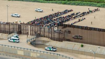 Vista aérea de migrantes agrupados mientras esperan ser procesados en el lado de la frontera de Ciudad Juárez en El Paso, Texas.