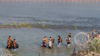Un grupo de migrantes cruza el río Bravo para ingresar ilegalmente a Texas.