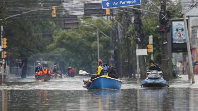 Rescatistas voluntarios navegan entre las calles inundadas en el barrio Humaita, este domingo en Porto Alegre (Brasil).