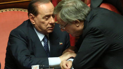 El exprimer ministro italiano y presidente del Pueblo de la Libertad (PDL), Silvio Berlusconi, conversa con el diputado de su partido Altero Matteoli.