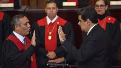 Venezuela's President Nicolas Maduro is sworn-in by the president of the Supreme Court of Justice (TSJ) Maikel Moreno (L) during the inauguration ceremony of his second mandate, at the TSJ headquarters in Caracas on January 10, 2019. - Maduro begins a new term that critics dismiss as illegitimate, with the economy in free fall and the country more isolated than ever. (Photo by YURI CORTEZ / AFP)
