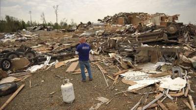 Unos hombres recuperan pertenencias en medio de los escombros en Mayflower R.V. Park tras el paso de un tornado que azotó este, 27 de abril, en Mayflower, Arkansas. EFE