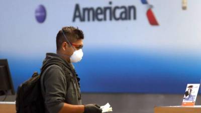 DALLAS, TEXAS - MARCH 13: A passenger checks in for an American Airlines in Terminal D at Dallas/Fort Worth International Airport (DFW) on March 13, 2020 in Dallas, Texas. American Airlines announced that it is cutting a third of its international flights amid a major slowdown due to the Coronavirus (COVID-19) outbreak. Tom Pennington/Getty Images/AFP== FOR NEWSPAPERS, INTERNET, TELCOS & TELEVISION USE ONLY ==